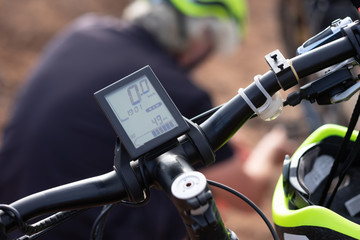 closeup of the handlebar and the device of a black electric bicycle. Time and distance control. Force adjustment.