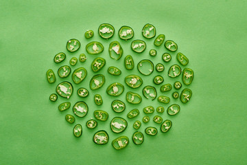 top view of cut and fresh peppers on green background