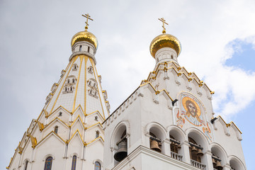 Bottom view of white christian church with bell-tower with image of Jesus Christ