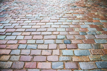 Naklejka premium Old stones road with pebbles in the city.