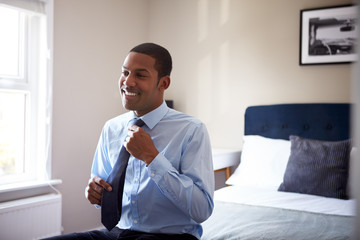 Young Man Getting Dressed In Bedroom For First Day At Work In Office - Powered by Adobe