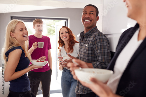Group Of College Students In Shared House Kitchen Eating Breakfast Together