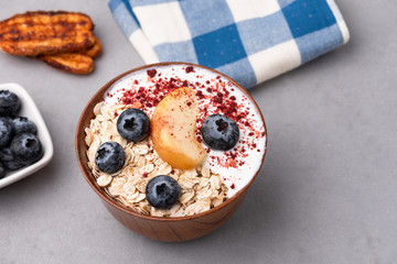 Granola, oatmeal with milk, peach and blue berry
