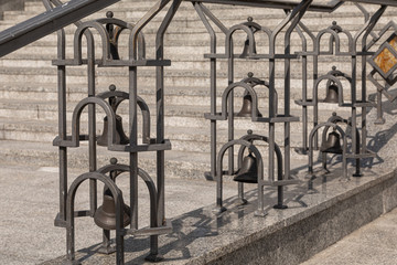 Close-up of wrought church bells in iron balustrade of outdoors staircase