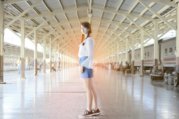 Beautiful young teen stood facing at train station.