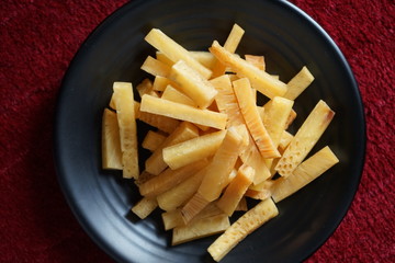 Crunchy fried of Breadfruits set on the black bowl, photographed on the red background.