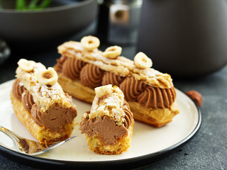 Homemade eclair with chocolate and nuts. Pastry.
