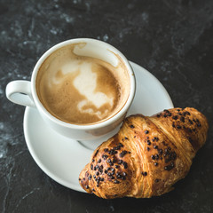 Cup of cappuccino and croissant