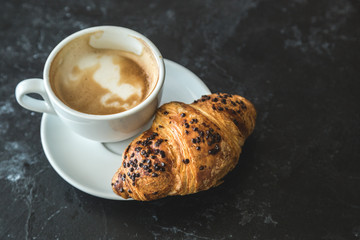 Cup of cappuccino and croissant