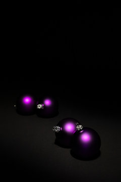 Purple Christmas balls on black background