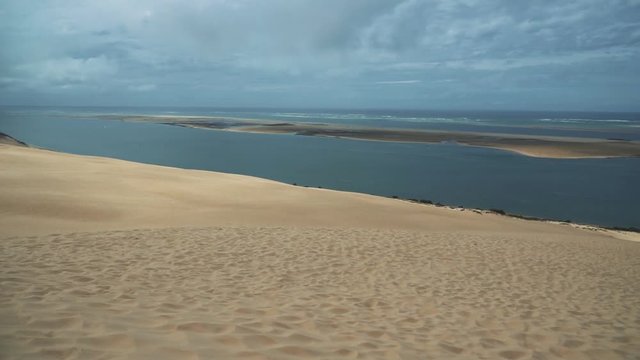 Famous Dune du Pilat near Bordeaux, France. A large sand dune by the atlantic seaside, filmed in slow motion.
