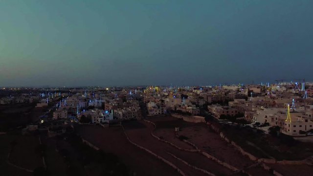 night aerial shot approaching Zurrieq village, Malta, flyover the terraced agricultural fields