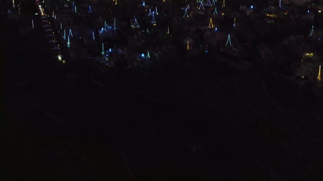 night aerial shot revealing Zurrieq village, shot over the colorful decoration lights for village fest