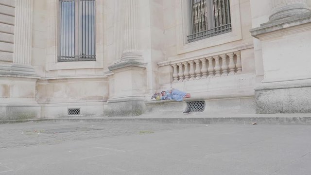 Still shot of homeless person sleeping on the bench in Paris.