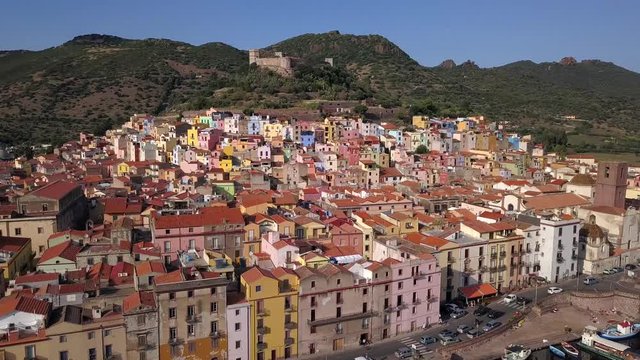 Bosa - Drone aerial shot, point of interest flying over the colourful town of Bosa and the castle on the hill top
