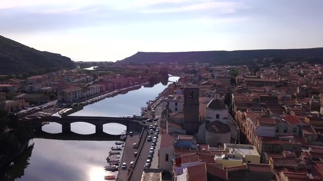 Bosa, Sardinia - Drone aerial shot at sunset over the colourful town of Bosa and the stone bridge on the river temo in Sardinia
