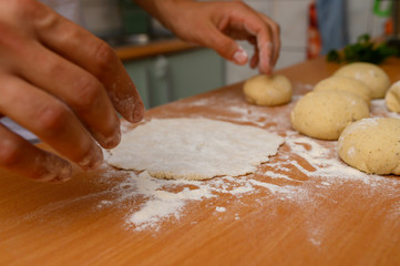 man preparing dough with flour