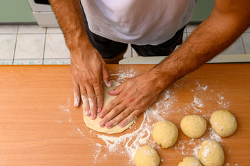 man preparing dough with flour