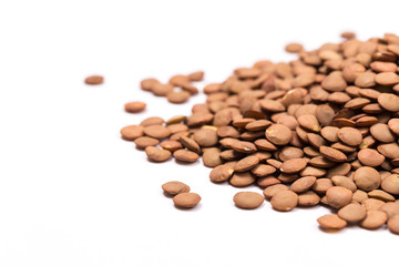 Isolated stack of uncooked lentils on white background from above.