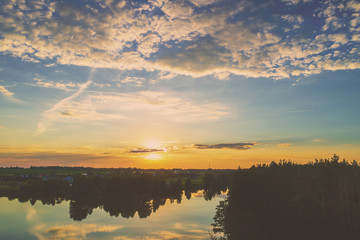 Magical sunrise over lake with a beautiful reflection on the water. Serene lake in the early morning. Nature landscape. Aerial view