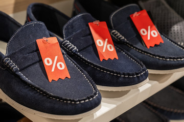 rack with  discounted shoe in a store. 50% sale on footwear in the supermarket