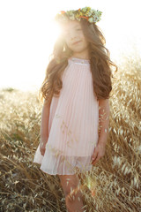 Little girl with a wreath and flowers on her head. 