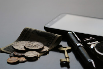 Still life of male cool belongings with dollar bills and coins