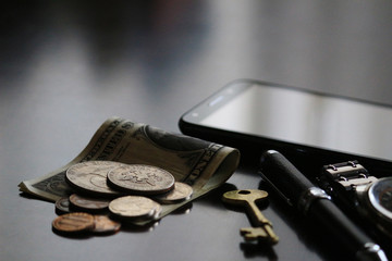 Still life of male cool belongings with dollar bills and coins