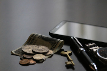 Still life of male cool belongings with dollar bills and coins