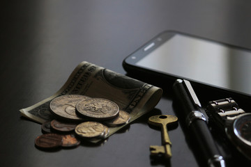 Still life of male cool belongings with dollar bills and coins