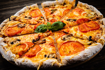 Pizza with tomatoes and champignon on cutting board