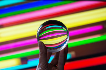 Reflections of colorful neons in a crystal ball. Astract colorful photography.