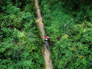 Cross country biking woman cyclist set the smartwatch on tropical forest trail