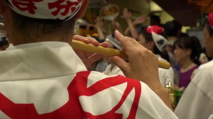 KOENJI, TOKYO, JAPAN - 24 AUGUST 2019 : Close up shot of blowing Japanese flute at AWA ODORI FESTIVAL (AWA DANCE FESTIVAL) in Koenji. Slow motion shot.