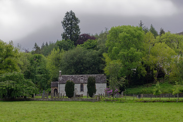 The small remote white washed Church at the small village of Glen Prosen, high up in the Angus Glens, on a wet day in June. Scotland.