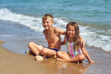 Cheerful children relax on the sea coast . Children's summer vacation