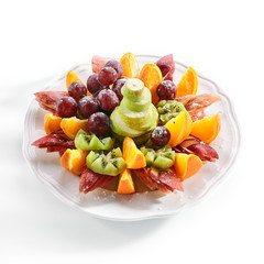 Fototapeta na wymiar Fruit Plate with Orange Wedges, Apple, Grapes, Kiwi and Pear
