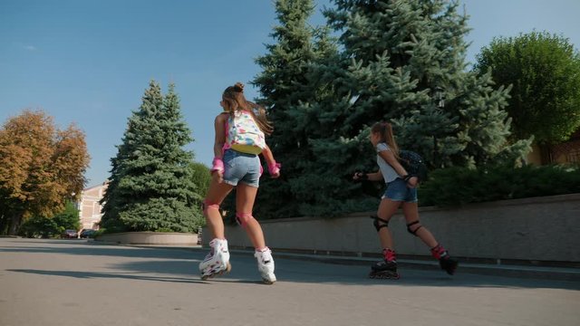Young active teen girls roller skating outdoor. Slow motion 4k video