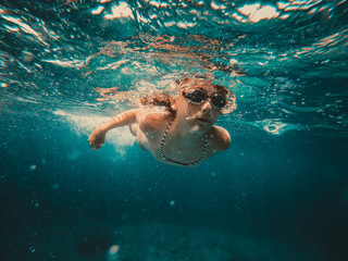 Underwater photo of girl swimming in the sea