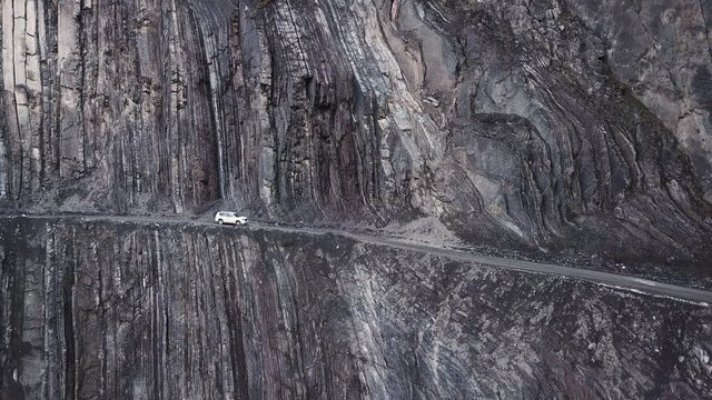 White SUV Driving On The Edge Of A Cliff In A Canyon