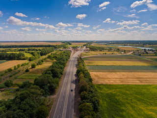 Aerial view of asphalt road passes through forest.