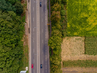Aerial view of asphalt road passes through forest. Top view.