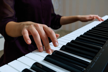 Fototapeta premium Young woman playing piano