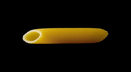 Penne rigate pasta, single, one noodle isolated on black background