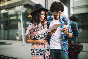 Summer holidays, dating, love and tourism concept - smiling couple with tablet in the city