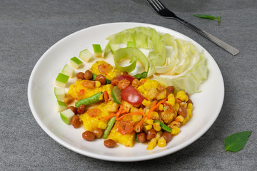 Fruit spicy salad in white dish on concrete table.