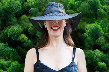 woman with black pamela smiling in front of a bamboos garden - Powered by Adobe