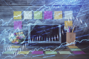 Double exposure of graph and financial info and work space with computer background. Concept of international online trading.