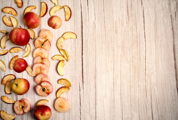 Summer composition. Fresh red apples, apple chips on a light wooden background.