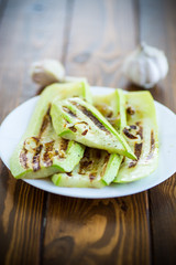 grilled zucchini with onions in a plate, on a table.